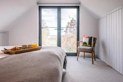 a bedroom with a bed with a tray of food and a chair at Chapel House, Alderton in Woodbridge