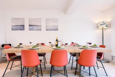 a dining room with a wooden table and orange chairs at Chapel House, Alderton in Woodbridge