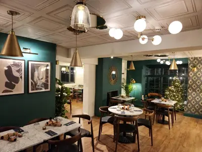 a restaurant with tables and chairs and a christmas tree at The Swan - A Colombo Edition Hotel in Ely