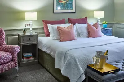 a bedroom with a bed with pink and white pillows at The Mistley Thorn in Mistley