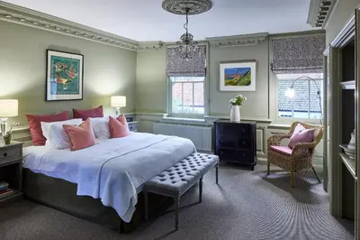 a bedroom with a bed and a chair and windows at The Mistley Thorn in Mistley