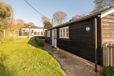 a black house with a yard next to a building at 9 Uplands in Thorpeness
