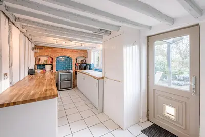 a large kitchen with a counter and a window at Jenny Rose Cottage, Wickham Market in Woodbridge