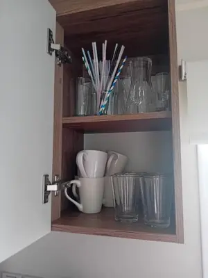 a cupboard with cups and glasses on a counter at Caravan in Jaywick,Jaywick sand, Clacton-on-sea in Jaywick Sands