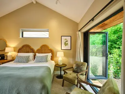 a bedroom with a bed and a chair and a window at The Weeping Willow in Bury Saint Edmunds