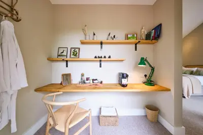 a room with wooden shelves and a chair and a bed at The Weeping Willow in Bury Saint Edmunds