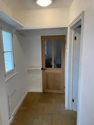a hallway with a wooden door and a window at Cosy Courtyard Cottage sleeps 4 with Log Burner, close to Cambridge in Cambridge