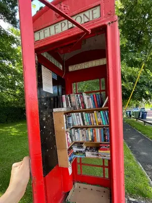 a red phone booth with books in it at Cosy Courtyard Cottage sleeps 4 with Log Burner, close to Cambridge in Cambridge