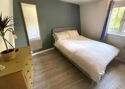 a bedroom with a bed with a dresser and a mirror at Cosy Courtyard Cottage sleeps 4 with Log Burner, close to Cambridge in Cambridge