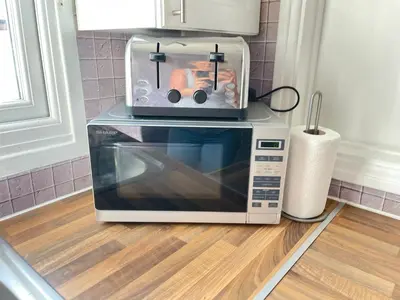 a toaster oven sitting on top of a microwave at King's - Spacious Central Ground Floor Apartment in Cambridge