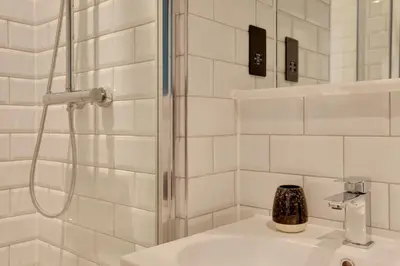 a white bathroom with a shower and a sink at New London Life Executive Apartments in Chelmsford