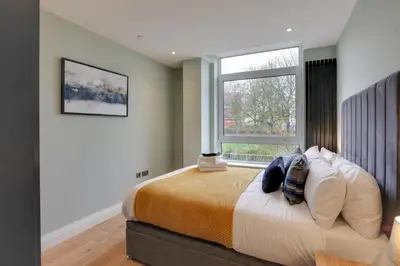 a bedroom with a large bed with a window at New London Life Executive Apartments in Chelmsford