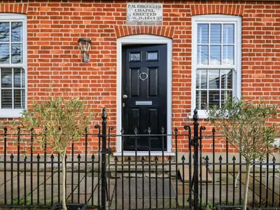 a black door on a brick house with a fence at Ebenezer Chapel in Saxmundham