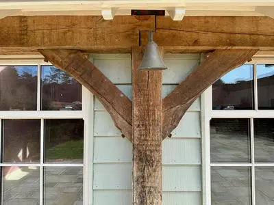 a beam in the front of a house with windows at Lynford Holiday Cottages nestled in the heart of Thetford Forest in Mundford