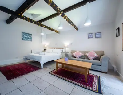 a room with a bed and a couch and a table at The Garden Cottage, Wenhaston, Suffolk, near coast in Halesworth