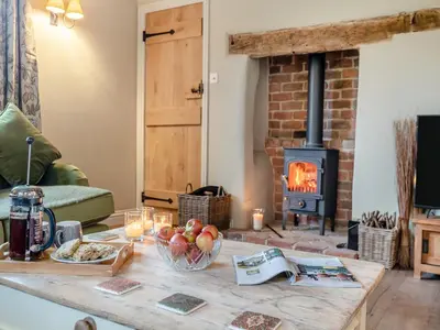 a living room with a coffee table with a wood stove at Hill Farm in Blyford