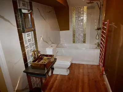 a bathroom with a toilet and a tub and a sink at Luxury 9 Bed Manor House Hot Tub Cinema Room SkyTV in Saffron Walden