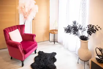 a black dog laying on the floor next to a red chair at Modern Pet-Friendly Apartment in Cambridge with Garden & Parking in Chesterton