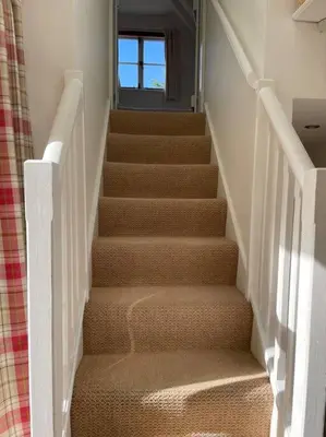 a stairway with stairs with a door and a window at Acacia Cottage in Halstead