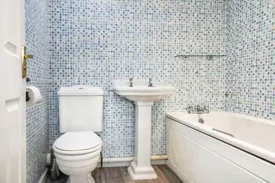 a bathroom with a toilet and a sink and a tub at Victoria Gardens in Colchester