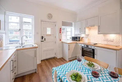 a kitchen with white cabinets and a plate of food on a table at Pelican Cottage, Aldeburgh in Aldeburgh
