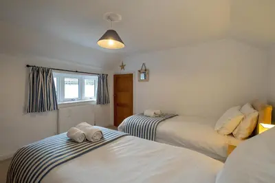 a bedroom with two beds with towels on them at The Pink House, Aldeburgh in Aldeburgh