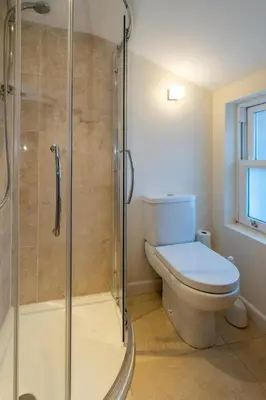 a bathroom with a toilet and a glass shower at The Pink House, Aldeburgh in Aldeburgh