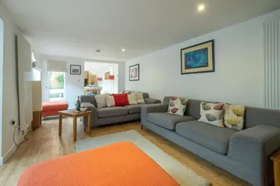 a living room with two couches and an orange rug at The Pink House, Aldeburgh in Aldeburgh
