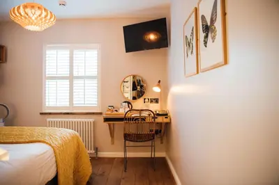 a bedroom with a bed and a desk and a window at The Fox at Willian in Letchworth
