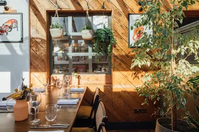 a dining room with a table and some plants at The Fox at Willian in Letchworth