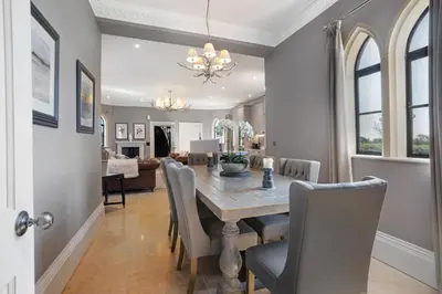 a dining room and living room with a table and chairs at South Lodge, St Osyth Priory in Saint Osyth