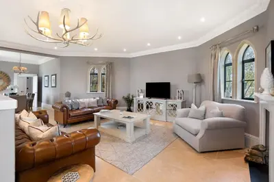a living room with a couch and a table at South Lodge, St Osyth Priory in Saint Osyth