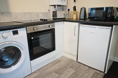 a kitchen with a washing machine and a microwave at Host & Stay - Clacton Coastal Hideaway in Clacton-on-Sea