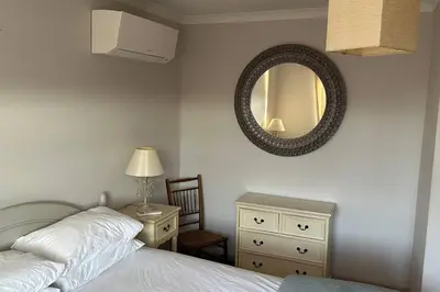 a bedroom with a bed and a mirror and a chair at Cosy 2 bed, home from home in Haddenham