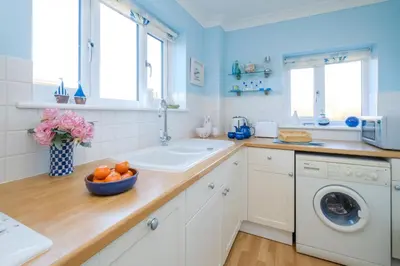 a kitchen with a sink and a washing machine at The Quarter Deck in Aldeburgh