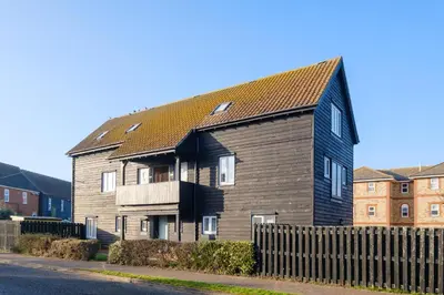 a large house with a black roof on a street at The Quarter Deck in Aldeburgh