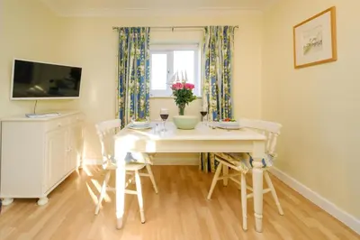 a dining room with a white table and chairs at The Quarter Deck in Aldeburgh