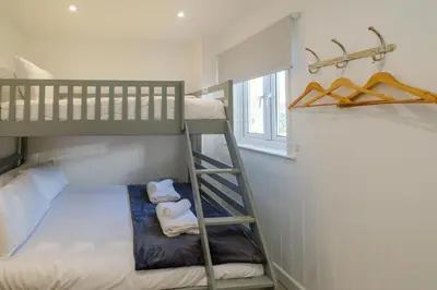 a small bedroom with bunk beds and a window at The Garden Flat in Aldeburgh