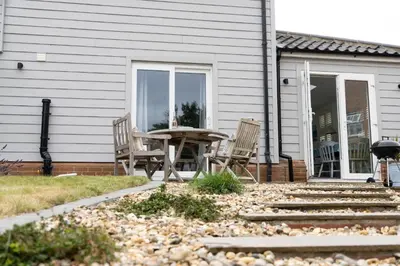 a patio with chairs and a table in front of a house at The Garden Flat in Aldeburgh