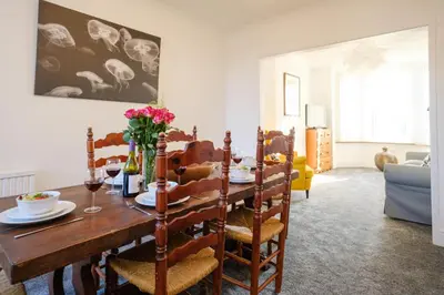 a dining room with a wooden table and chairs at 39 Carr Avenue - Aldeburgh Coastal Cottages in Leiston