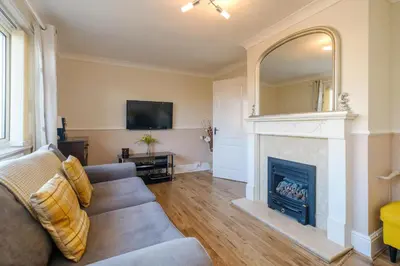a living room with a couch and a fireplace at 61 Fairfield Road in Aldeburgh