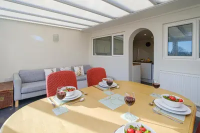 a dining room with a table with wine glasses at 61 Fairfield Road in Aldeburgh