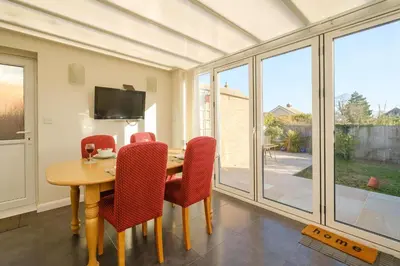 a dining room with a wooden table and red chairs at 61 Fairfield Road in Aldeburgh
