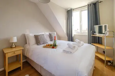 a bedroom with a white bed with towels on it at 61 Fairfield Road in Aldeburgh