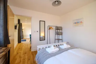 a bedroom with a bed with two white towels at Three Tuns - Garden Suite 1 in Wickham Market