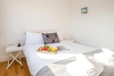 a white bed with a tray of fruit on it at Three Tuns - Garden Suite 1 in Wickham Market