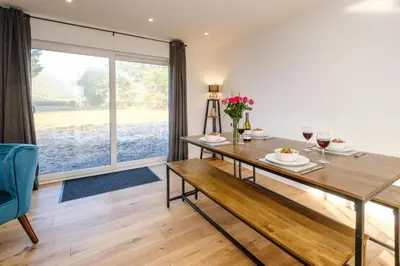 a dining room with a table and a large window at Three Tuns - Garden Suite 1 in Wickham Market