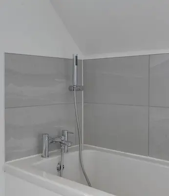 a bath tub with a shower head and a sink at Towerview Apartments Braintree in Braintree