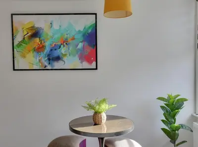a table and two chairs in a room with a painting at Towerview Apartments Braintree in Braintree