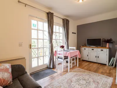 a living room with a table and a window at Rector's Retreat in Ipswich